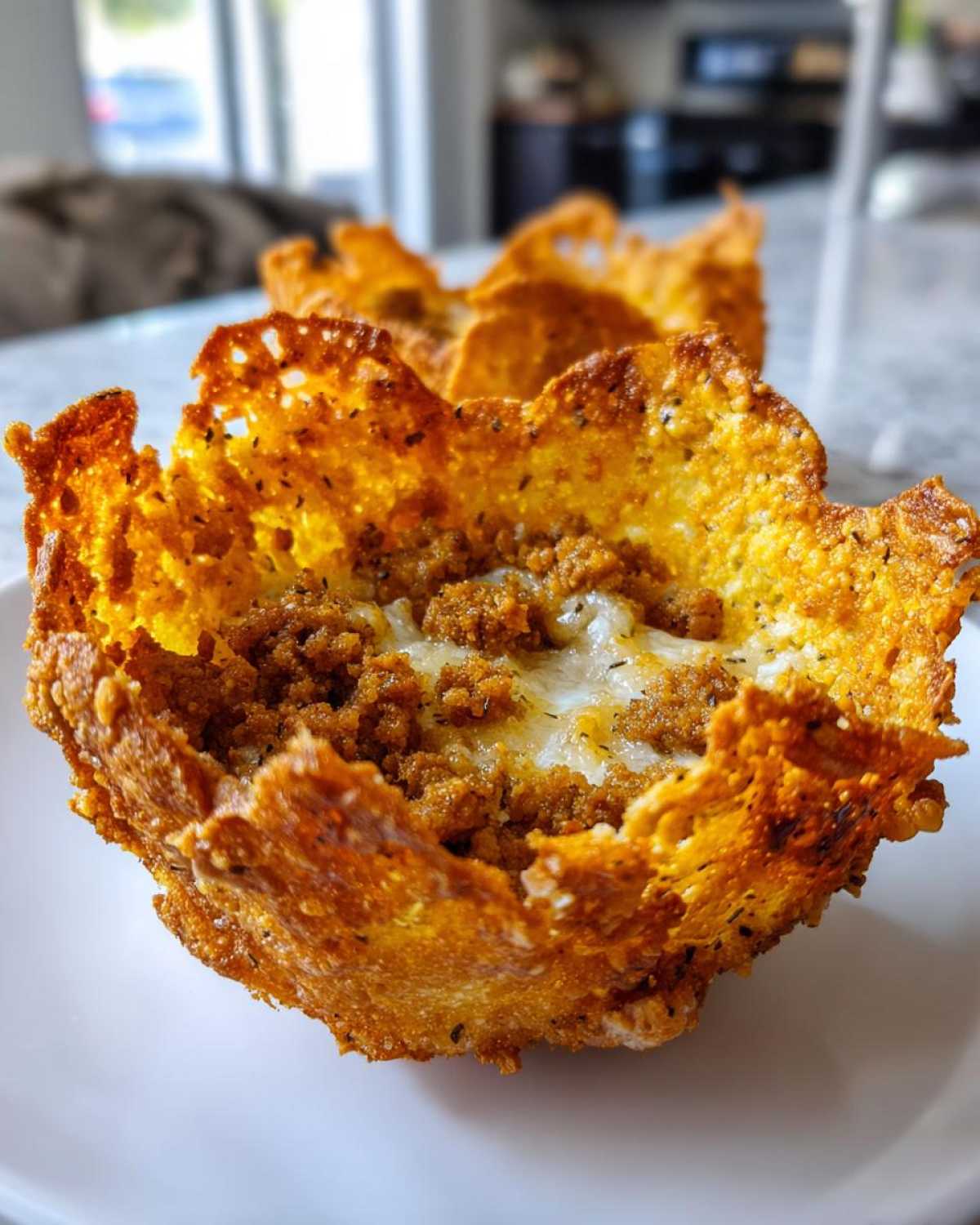 Close-up of a Keto Crispy Cheese Taco Shell Bowl filled with seasoned ground meat and melted cheese.