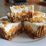 Close-up of No-Bake Carrot Cake Cheesecake Cups, showing a thick graham cracker crust, creamy filling with visible carrots, and cream cheese topping.