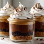 Three individual No-Bake Chocolate Peanut Butter Pie Jars featuring layers of crust, chocolate mousse, peanut butter filling, and whipped cream topping.