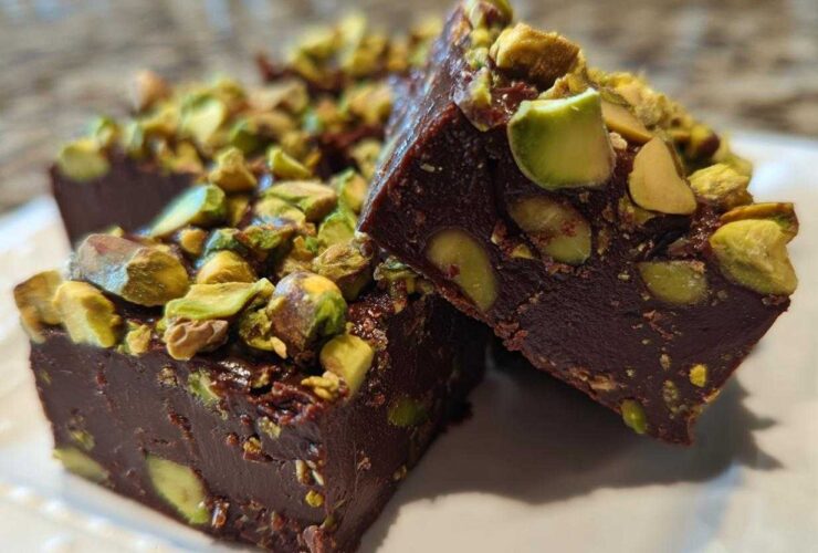 Close-up of rich, dark No-Bake Pistachio Chocolate Fudge Squares topped with chopped pistachios.