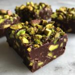 A rich, dark chocolate square loaded with bright green pistachios, part of the No-Bake Pistachio Chocolate Fudge Squares.