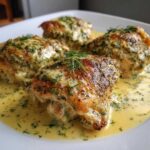 Four perfectly cooked One-Pan Creamy Lemon Dill Chicken Thighs served in a rich, yellow sauce topped with fresh dill.