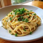 Close-up of One-Pot Creamy White Bean Lemon Pasta tossed in a rich sauce and topped with fresh parsley.
