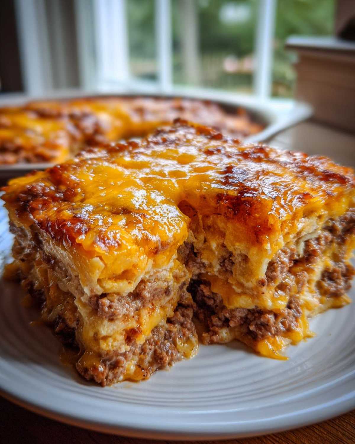 A close-up serving of Pioneer Woman Taco Casserole showing layers of seasoned ground beef and melted cheddar cheese.