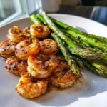 Close-up of Sheet Pan Crispy Garlic Butter Shrimp and Asparagus, glistening with butter and lemon zest.