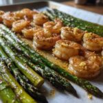 Close-up of Sheet Pan Crispy Garlic Butter Shrimp and Asparagus cooked together on parchment paper.