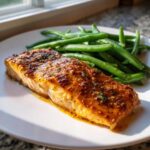 A perfectly cooked fillet of Sheet Pan Honey Mustard Salmon and Green Beans served on a white plate.