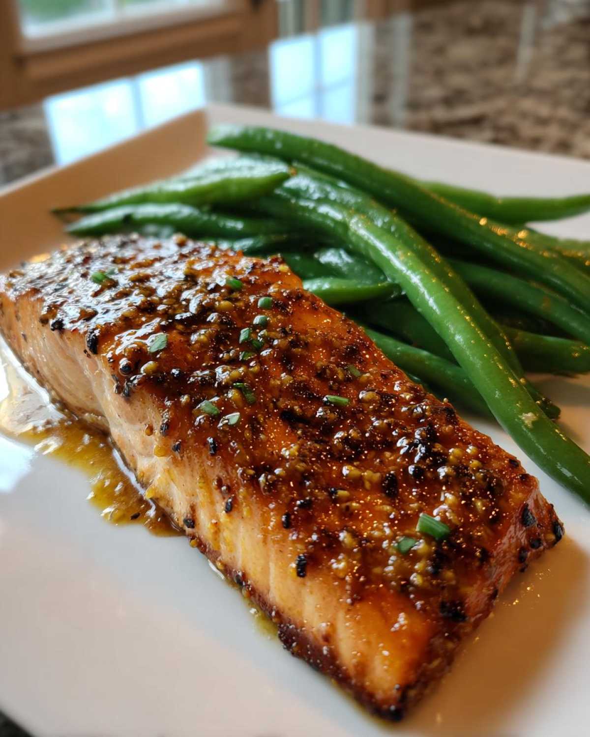 Close-up of a perfectly cooked fillet of Sheet Pan Honey Mustard Salmon and Green Beans on a white plate.