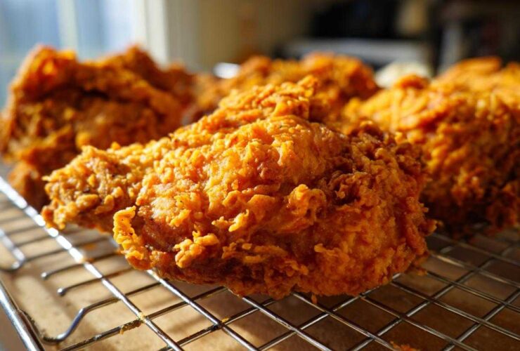 Close-up of perfectly cooked Southern Fried Chicken Crispy Golden resting on a wire cooling rack.