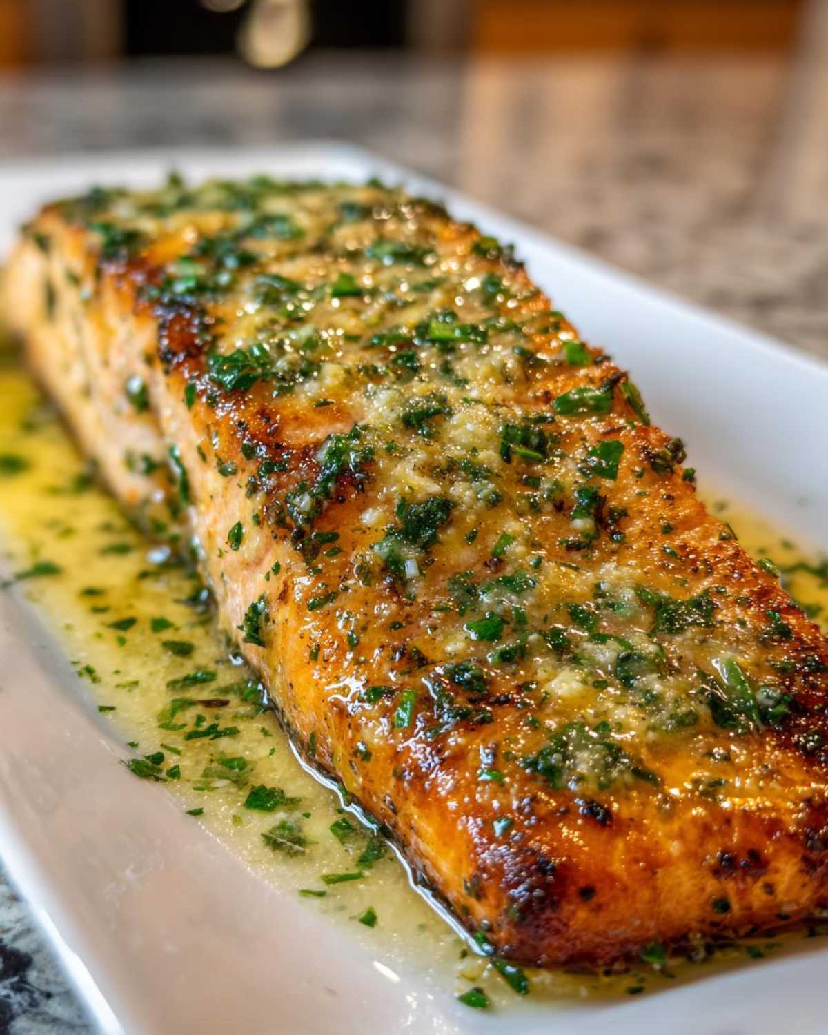 A perfectly cooked fillet of Texas Roadhouse Salmon covered in glistening garlic butter sauce and fresh parsley.