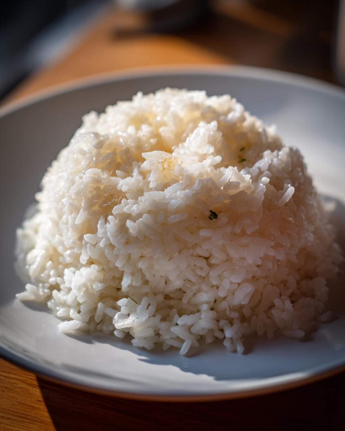 A mound of fluffy white Texas Roadhouse Seasoned Rice served on a white plate under bright lighting.